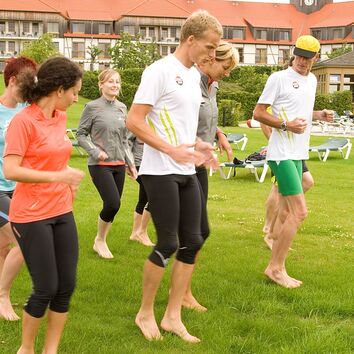 Gruppe bei Fußstabilisationsübungen im Gras